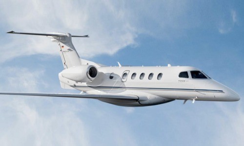Phenom 300 private jet flying above the sea