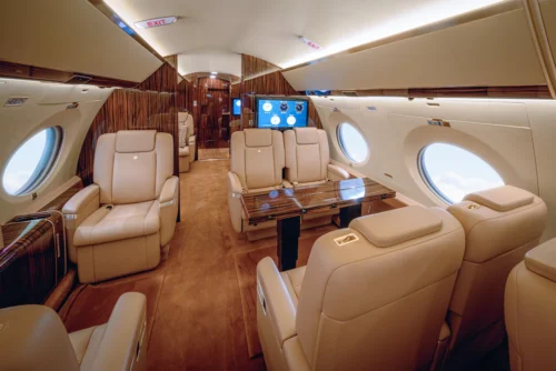 Luxurious cabin interior of the Gulfstream G650ER featuring leather seats, wood accents, and executive layout